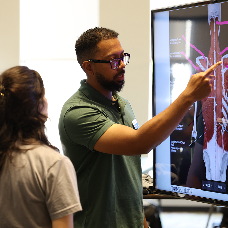 Faculty instructing a student on human anatomy.