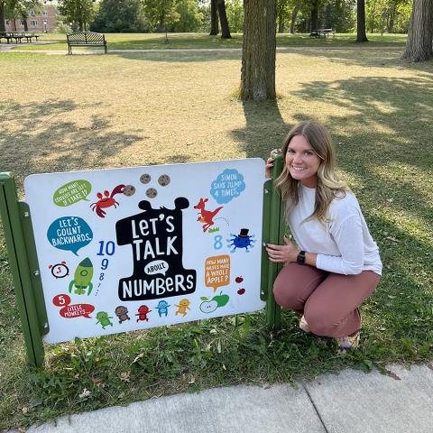Ariel Mansholt crouching next to number board in park